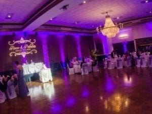 In the heart of a majestic banquet hall, resplendent with purple hues of enchantment, tables are set with grace beneath a breathtaking chandelier that dazzles like the emblem of justice. Enter Event Heroes! With flair and expertise, they infuse the scene with electrifying excitement through their top-tier photo booth rental powers, preserving heroic moments with unmatched style and precision. The gathering is now not just an event but an unforgettable saga of memories!. :The Event Heroes at Black Tie Productions