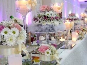 In a grand assembly of love and unity, the wedding reception unfurls its splendor, featuring majestic tables adorned with elegant floral centerpieces standing proud like guardians of romance. Flickering candles cast their warm glow like beacons of hope, while soft event lighting bathes the scene in a gentle luminescence. To elevate this epic celebration to legendary status, summon the power of a Michigan wedding DJ—an orchestrator of rhythm and harmony—who will amplify your joy and ensure an unforgettable experience for all who gather in this sanctuary of devotion. :The Event Heroes at Black Tie Productions