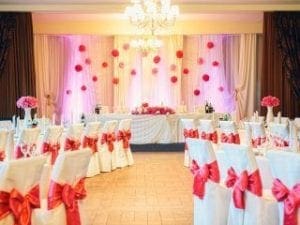 In the heart of romance, the wedding reception transformed into a realm of elegance and heroism. Chairs clad in powerful pink bows stood proudly, like stalwart guardians of love; tables bore magnificent pink centerpieces, a testament to unity and harmony. Above all, a breathtaking pink and white backdrop shimmered under the glow of exquisite chandeliers—a beacon of everlasting joy. To magnify this celebration with sonic wonder or capture moments thatll echo through time, enlist the legendary Michigan wedding DJ services or embark on an exhilarating adventure with our Event Heroes photo booth rental. Let your day soar to heroic heights!. :The Event Heroes at Black Tie Productions