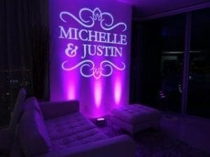In a lair aglow with mystic purple hues, elegant couches line the chamber where legends are forged. A grand projection illuminates the names Michelle & Justin, casting their union into eternity. Black Tie Productions is the secret weapon, infusing an air of sophistication and style into this epic Michigan wedding DJ experience, creating a memorable moment that will echo throughout the cosmos. :The Event Heroes at Black Tie Productions
