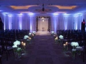 In a universe where love unites in spectacular fashion, the wedding aisle acts as your radiant runway, aglow with the gentle shimmer of candles and adorned with a cascade of pristine white blossoms. This path leads to the magnificently crafted archway where destinies converge. Stationed on either side, legions of guests await this heroic chapter. For a music experience that orchestrates flawless harmony and unforgettable moments at a Michigan wedding, summon Event Heroes—the maestros dedicated to crafting seamless celebrations!. :The Event Heroes at Black Tie Productions