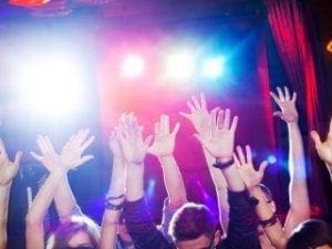 In the heart of an electrifying realm, the Event Heroes soar above, transforming the night with their extraordinary powers. Amidst a sea of jubilant citizens, hands thrust skyward in triumph, they unleash a dazzling display of vibrant stage lights that cast an enchanting glow across the scene. Each pulse of energy they release ignites infectious joy, turning every heartbeat into a legendary moment that echoes through time—a celebration immortalized by their heroic touch!. :The Event Heroes at Black Tie Productions