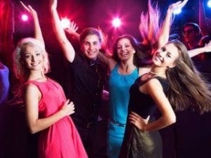 In the heart of an electrifying dance floor, where colorful lights blaze like cosmic energy beams, stand four extraordinary individuals. With smiles brighter than a supernova and poses bursting with dynamic power, they embody the vibrant essence conjured by none other than Black Tie Productions. Their presence transforms the room into a realm of pure exhilaration, radiating joy and heroism through every spirited movement. :The Event Heroes at Black Tie Productions