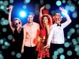 In a realm electrified with vibrant energy, four extraordinary individuals gather at a dynamic celebration. Clad in the ultimate festive armor and dazzling in heroic accessories that catch every eye, they stand together against the cosmos of ordinary. The atmosphere pulsates with rainbow-hued lights and mesmerizing bokeh effects, an otherworldly ambiance masterfully conjured by the legendary architects of vision, Black Tie Productions. :The Event Heroes at Black Tie Productions