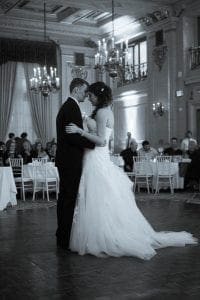 In the heart of an opulently adorned ballroom, where elegance reigns supreme and the air crackles with an electric anticipation orchestrated by the masterful Black Tie Productions, our heroic couple takes center stage. The bride and groom glide across the dance floor like graceful titans, their every move illuminated by celestial beams of exquisite light. Their love story captivates all in attendance as guests, seated at tables draped in refined splendor, bear witness to this legendary first dance—a moment charged with extraordinary romance in a symphony of light and motion. :The Event Heroes at Black Tie Productions