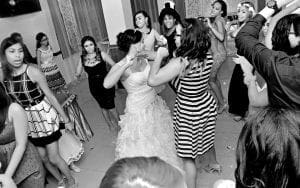 In a grand ballroom where elegance meets exhilaration, a dazzling scene unfolds. Attendees dance exuberantly in their regal attire, with flowing gowns and immaculate suits swaying to the rhythm of unseen heroics. At the center of this joyous spectacle stands the majestic figure in a gown reminiscent of bridal beauty—an emblem of celebration. Black Tie Productions, the unsung heroes behind the curtain, weave their magic effortlessly to heighten the grandeur. Their powers manifest through impeccable entertainment and transformative services like photo booth portals, capturing memories that will endure through time. :The Event Heroes at Black Tie Productions