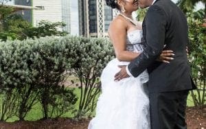 In a garden of dreams, where nature sets the stage for heroes of love, a couple stands united in elegance and grace. Cloaked in valor, the woman dazzles like a radiant beacon in her strapless white gown. By her side, the man exudes sophistication and strength, his black suit a perfect counterpart to her brilliance. Together, they create a force field of enchantment amidst the verdant backdrop and majestic buildings. This is no ordinary moment—its an epic chapter in their story of commitment and celebration at this Michigan wedding DJ scene. :The Event Heroes at Black Tie Productions