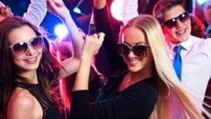 Under the dazzling glow of vibrant event lights, a spirited band of revelers don their stylish sunglasses as they unleash their electrifying dance moves upon the dance floor. With an energy that crackles through the air like lightning, they embody the infectious rhythm expertly orchestrated by a legendary Michigan wedding DJ. In this dynamic arena of sound and color, their every step is a testament to the power of unity and joy—a celebration so formidable it transforms an ordinary night into an epic adventure worthy of superheroic tales!. :The Event Heroes at Black Tie Productions