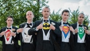 Five mighty figures clad in suits gather beneath the open sky, each a guardian of justice poised to protect the world. As their hand-tailored jackets part, five iconic emblems burst into view—The Flashs lightning bolt crackles with speed; The Punishers skull glows with fierce determination; Batmans silhouette looms with shadowy resolve; Supermans S gleams with hope; and Green Lanterns ring shines brilliantly, fueled by willpower. Together, they stand as Event Heroes, prepared to leap into action and save the day from whatever challenges may arise. :The Event Heroes at Black Tie Productions