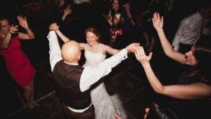 Under the dazzling glow of expertly crafted lights, Bride Brilliance and Groom Gallant twirl majestically at the heart of an electrified crowd. Friends and family, transformed into a league of jubilant revelers, raise their hands in triumph. The dynamic beats from Maestro Mixmaster—the legendary Michigan DJ—keep the atmosphere charged with a powerful energy that could rival even the mightiest superhero festivities!. :The Event Heroes at Black Tie Productions