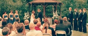 In the heart of the garden kingdom, beneath a majestic gazebo, the Bride and Groom stood as champions of their love. To their left, the Bridesmaid Brigade donned elegant blue capes—battle-ready and radiant. To their right, in sharp suits that gleamed like armor under sunlight, stood the Groomsmen Guardians. Below them, a gathering of noble guests filled the foreground like an army poised to celebrate this epic union. Enhancing this extraordinary day were none other than Event Heroes, swooping in with legendary services! Their state-of-the-art photo booth rentals engaged all attendees, turning moments into memories as everyone united to honor this heroic bond. :The Event Heroes at Black Tie Productions