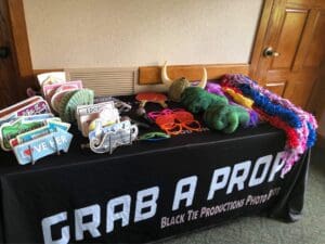 Attention, party heroes! Unleash the power of memories with our incredible photo booth rental! Our legendary table is armed with a thrilling arsenal of props—mighty signs, epic hats, dazzling sunglasses, and fabulous feather boas—all under the banner Grab a Prop. Perfect for capturing those unforgettable moments at your epic event! Illuminate your celebration by inquiring about our event lighting options and receive a lightning-fast price quote. Get ready to light up the night and become the hero of your own adventure!. :The Event Heroes at Black Tie Productions