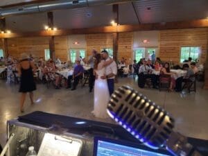 Amidst the electrifying glow of vibrant event lighting, a dynamic duo takes center stage in the grand reception hall. Their every move is framed by the silhouette of an iconic microphone, standing as a sentinel to their epic display. Around them, seated admirers gaze in awe, their faces aglow with pure delight as they witness this extraordinary spectacle unfold. :The Event Heroes at Black Tie Productions