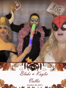 In a dazzling display of vibrant heroics, three dynamic figures assemble in their splendid guises, ready to conquer the evening with laughter and joy. One dons the mighty Viking helmet, exuding an air of ancient power; another flaunts a brilliant feather boa, embodying elegance and whimsy; while the third sports oversized glasses that magnify their heroic vision. Each wields not a weapon but a glow stick—illuminating the path to celebration! They gather before an iconic backdrop proclaiming Blake & Kaylie, Vallie, October 28, 2023, where love takes center stage. With flair and panache worthy of legendary status, they transform any festivity into an unforgettable epic through expert photo booth rentals and spectacular event lighting—because every hero knows how to light up the night!. :The Event Heroes at Black Tie Productions